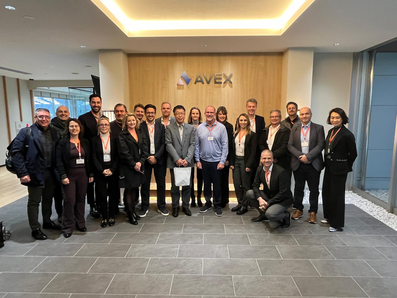 The TWI Institute Japan tour group poses for a picture in the Avex lobby during their tour of the factory building.