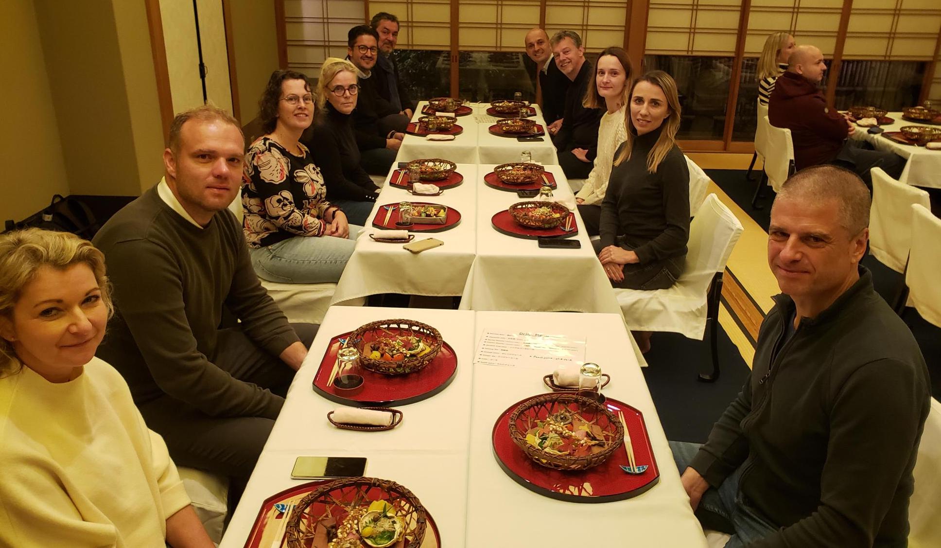 Travelers on the TWI Institute Japan tour sit together in a traditional Japanese restaurant to sample the taste and presentation of Japanese food.