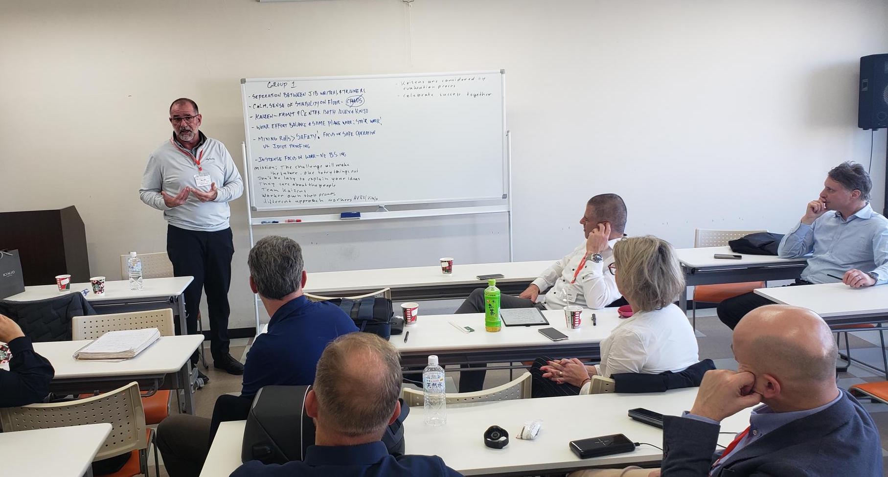 Travelers on the TWI Institute Japan tour sit in a classroom to attend a presentation on Standardized Work.