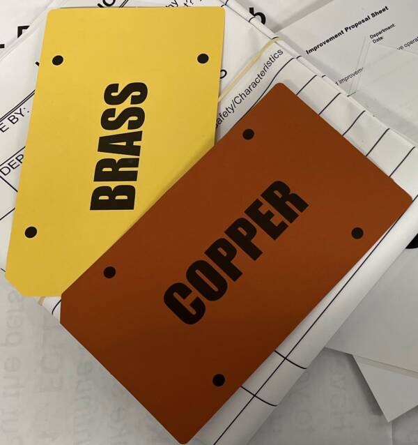 A brown card that says copper and a yellow card that says Brass
